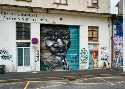 Baiona, en langue basque c'est Bayonne 15 une personne racisée (noire) peinte sur un volet roulant, sur la rive doite de l'Adour