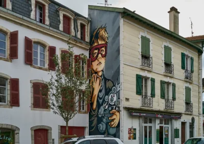 Baiona, en langue basque c'est Bayonne 20 dans un mur en retrait une fresque , toute verticale, représentant un garçon avec un masque rouge accompagné de son doudou