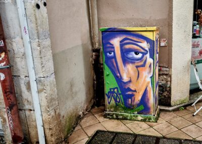 Peinture sur un coffret technique Telecom, un homme au regard triste nous regarde, passer dans la rue