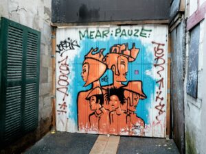 au fond d'une cour étroite, entre deux bâtiments, 5 personnages fétiches, déclinés en 3 couleurs, d'EXIST