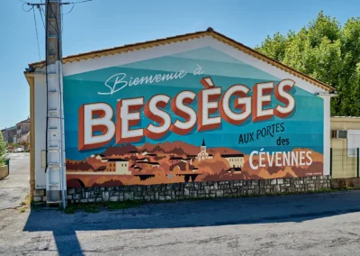 Panneau d'accueil à l'entrée de ville de Bessèges (Gard) flamboyant et coloré avec un lettrage soigné (collectif Lettres Capitales)